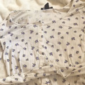 Dainty floral shirt with a unique texture to the touch and white accent buttons.